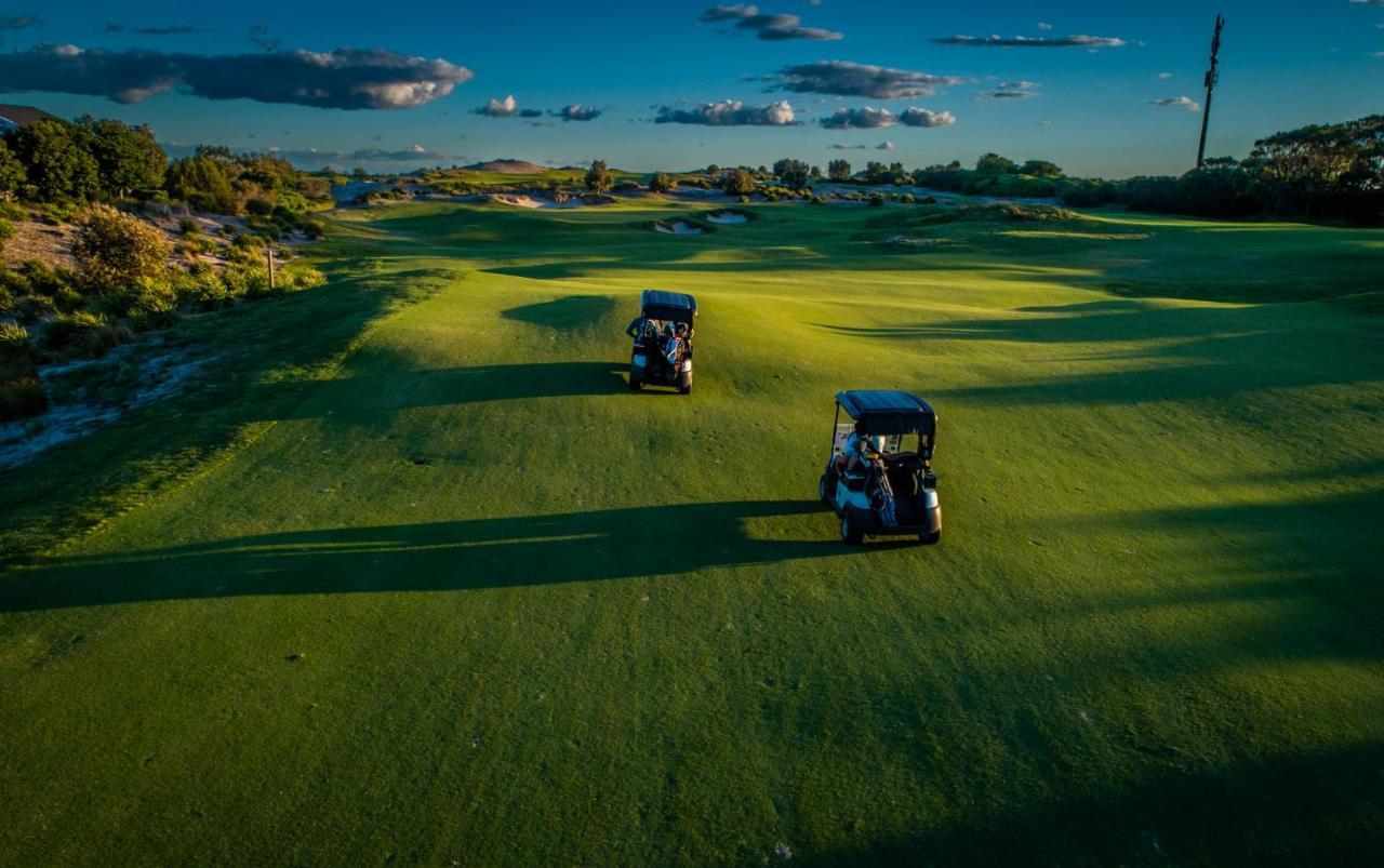 Pullman Magenta Shores Resort Entrance Luaran gambar Golf carts on the green